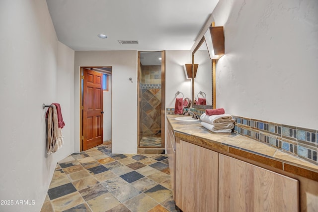 bathroom featuring visible vents, stone finish floor, recessed lighting, vanity, and a stall shower