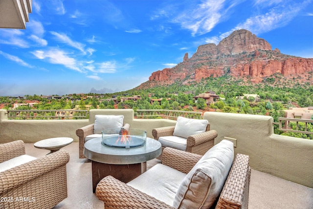 view of patio / terrace featuring an outdoor living space with a fire pit, a mountain view, and a balcony