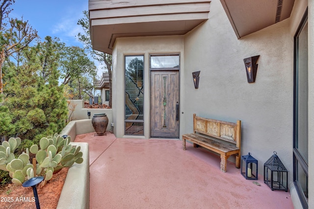 doorway to property with a patio area and stucco siding