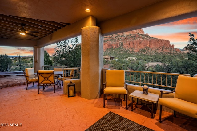 patio terrace at dusk with outdoor dining area and a balcony