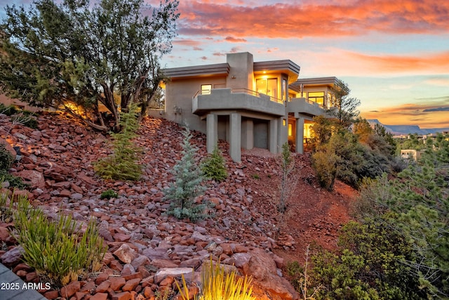 view of front of home featuring a balcony and stucco siding