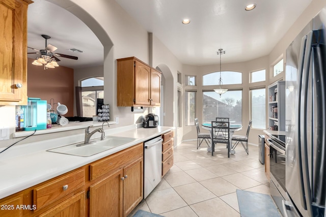 kitchen featuring sink, hanging light fixtures, light tile patterned floors, ceiling fan, and stainless steel appliances