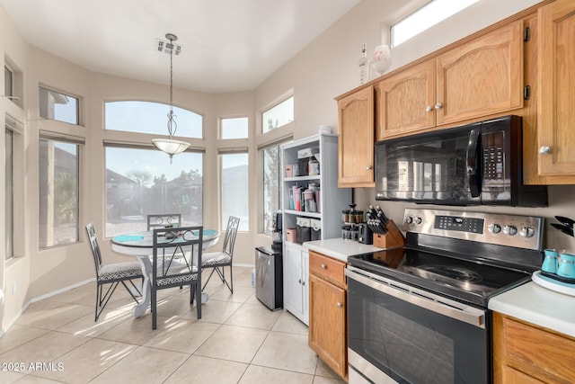 kitchen with hanging light fixtures, electric range, and light tile patterned floors