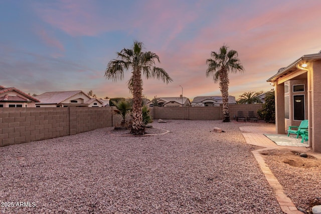 yard at dusk featuring a patio area