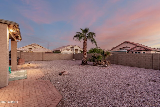 yard at dusk featuring a patio