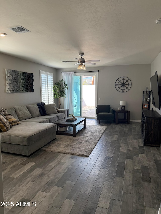 living room with dark wood-type flooring and ceiling fan