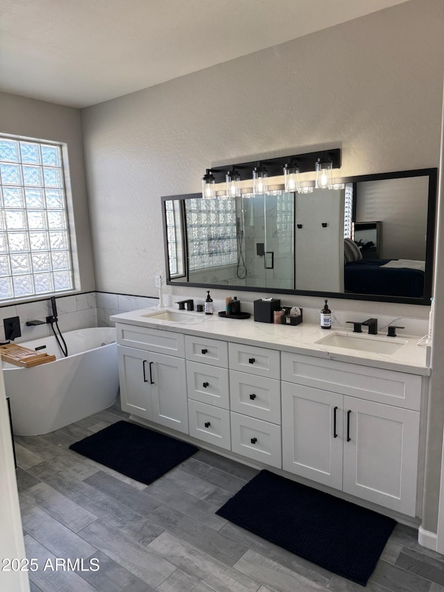 bathroom with vanity, separate shower and tub, and hardwood / wood-style floors