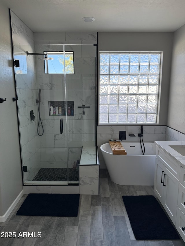 bathroom featuring plenty of natural light, plus walk in shower, wood-type flooring, and vanity