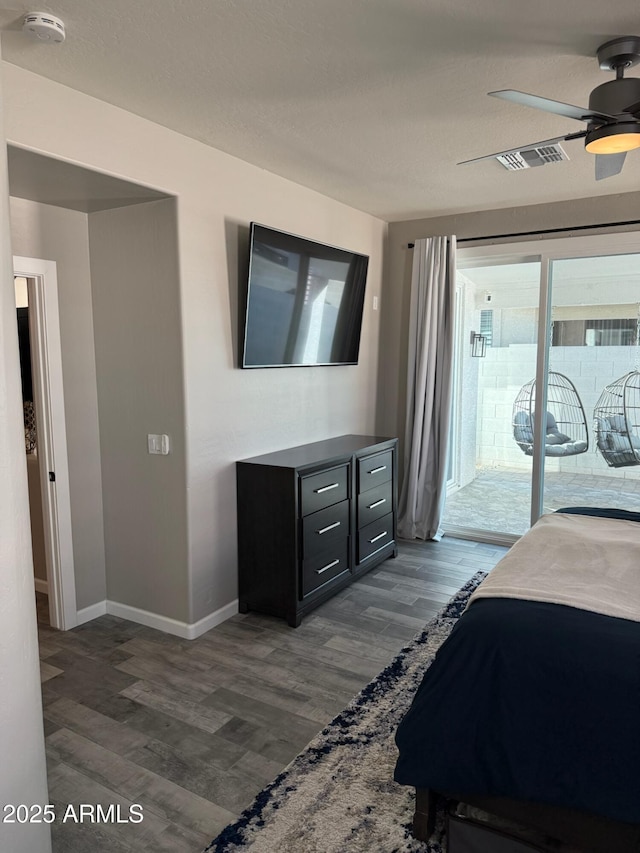 bedroom with ceiling fan, dark hardwood / wood-style flooring, a textured ceiling, and access to outside