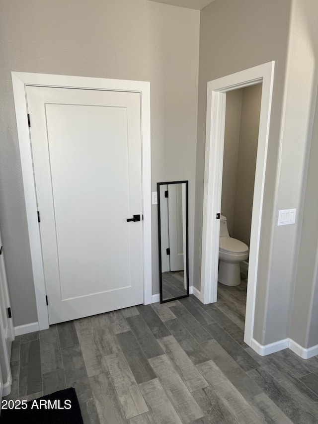 unfurnished bedroom featuring wood-type flooring and connected bathroom