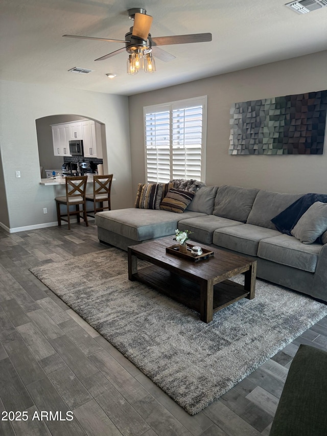 living room featuring wood-type flooring and ceiling fan