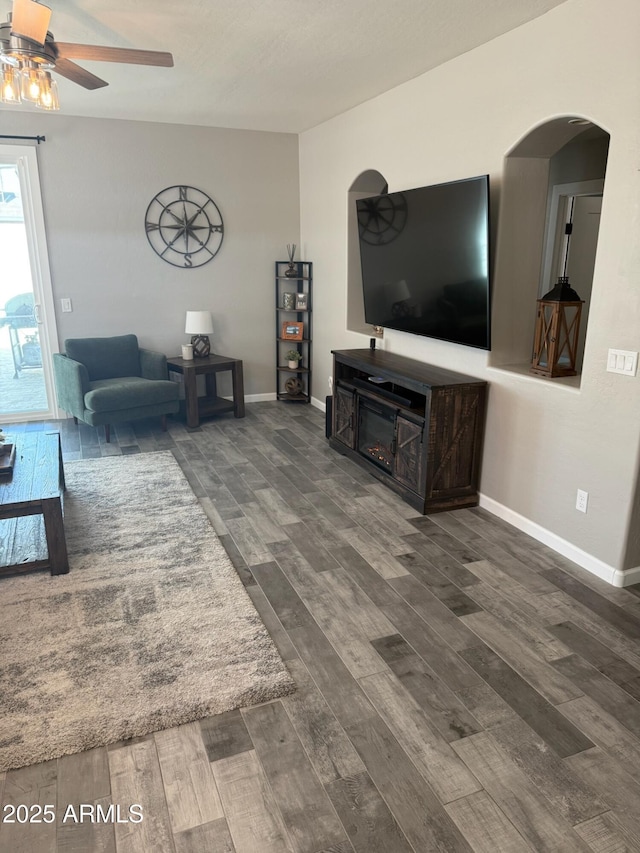 living room with dark hardwood / wood-style flooring and ceiling fan