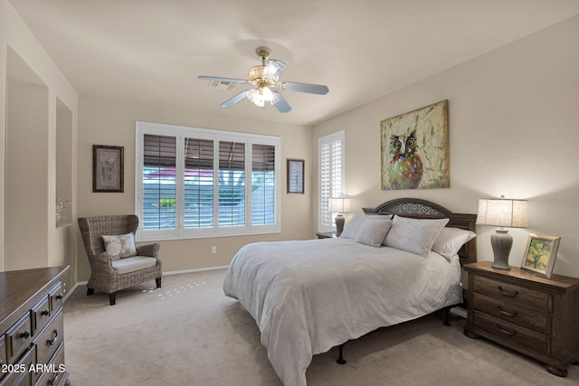 bedroom with multiple windows, ceiling fan, and light colored carpet