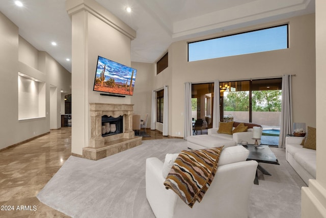 living room featuring a fireplace and a towering ceiling