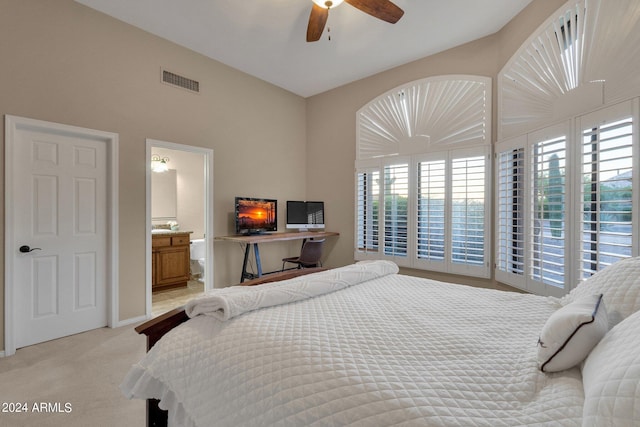 bedroom with light carpet, ensuite bath, and ceiling fan