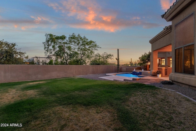 yard at dusk with an outdoor kitchen and a patio