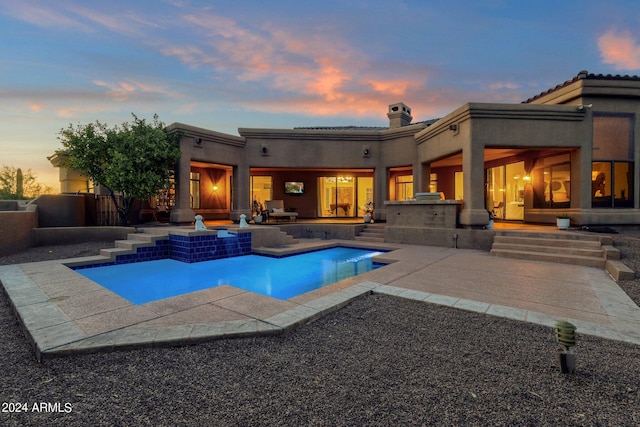 pool at dusk featuring a patio area