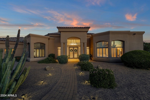 back house at dusk featuring french doors