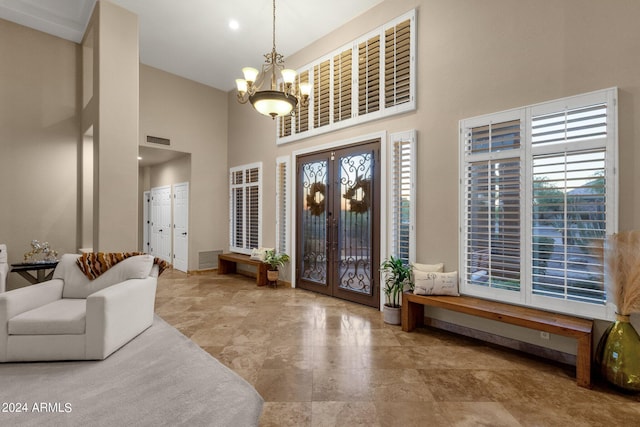 entryway with a towering ceiling and a notable chandelier