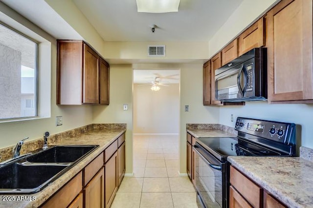 kitchen with light tile patterned flooring, sink, ceiling fan, and black appliances