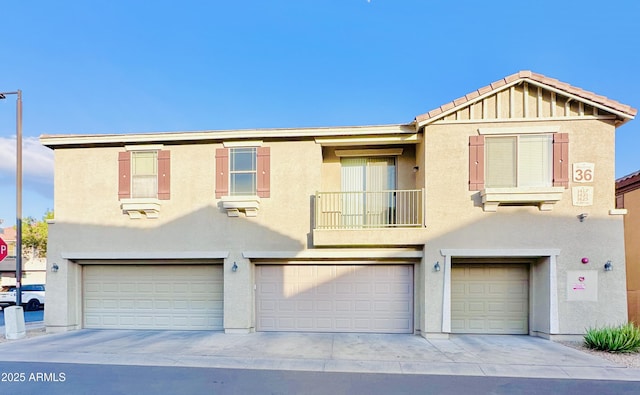 view of property with a balcony and a garage