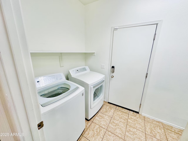 laundry room with washer and clothes dryer and light tile patterned floors