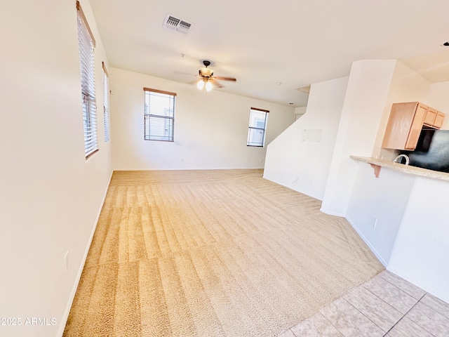 unfurnished living room featuring ceiling fan and light tile patterned floors