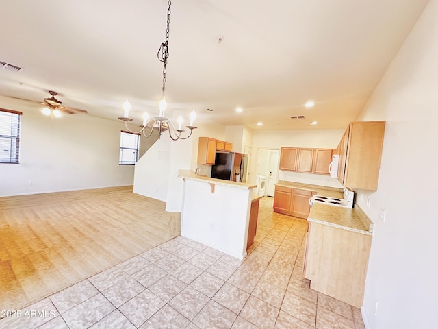 kitchen with light brown cabinets, white appliances, ceiling fan with notable chandelier, light tile patterned flooring, and kitchen peninsula