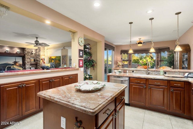 kitchen with sink, decorative light fixtures, stainless steel dishwasher, and a center island