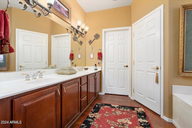 bathroom featuring an inviting chandelier, vanity, a bathing tub, and wood-type flooring