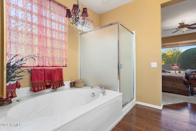 bathroom featuring hardwood / wood-style flooring, independent shower and bath, and ceiling fan with notable chandelier