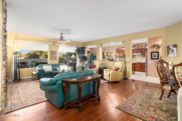 living room featuring ceiling fan and dark hardwood / wood-style flooring