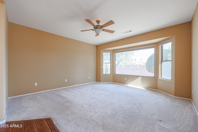 spare room with light colored carpet and ceiling fan