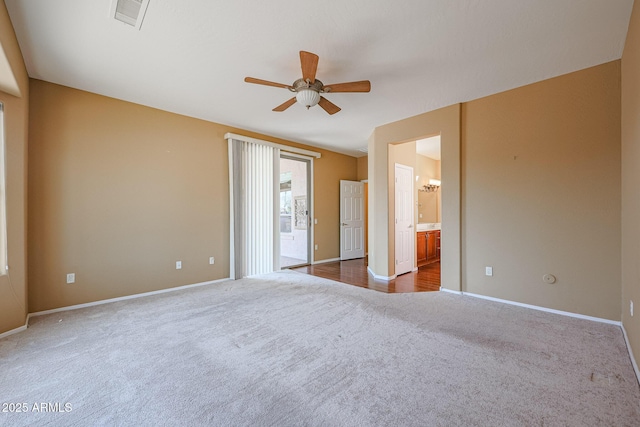 unfurnished bedroom featuring ceiling fan, ensuite bath, and carpet flooring