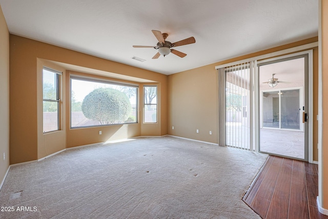 carpeted spare room with ceiling fan