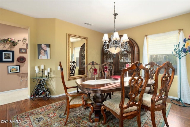 dining area with dark hardwood / wood-style floors and a chandelier