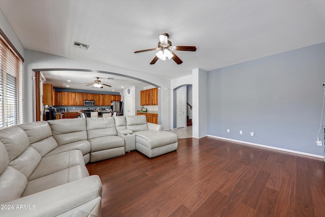 living room featuring ceiling fan and dark hardwood / wood-style flooring