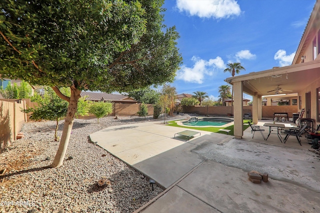 view of patio featuring ceiling fan and a fenced in pool