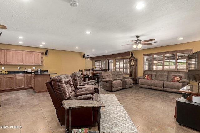 living area featuring light tile patterned floors, ceiling fan, a textured ceiling, and recessed lighting