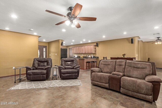 living room featuring wet bar, a ceiling fan, and recessed lighting