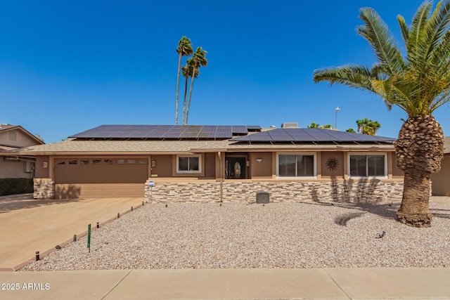 ranch-style home featuring an attached garage, stone siding, driveway, and stucco siding