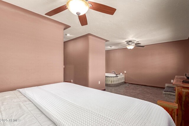 bedroom with a ceiling fan, a textured ceiling, and baseboards