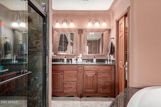 bathroom with a sink, a shower stall, and double vanity