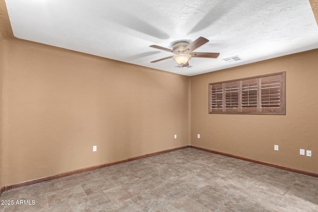 spare room with baseboards, visible vents, and a ceiling fan