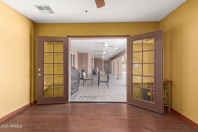 entryway featuring baseboards, wood finished floors, visible vents, and a ceiling fan