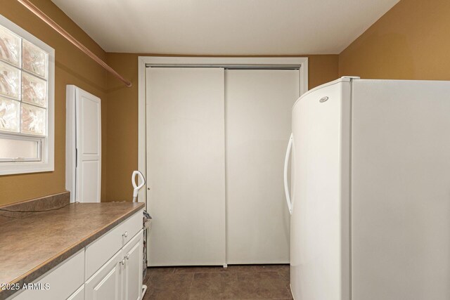 kitchen with white cabinets and freestanding refrigerator