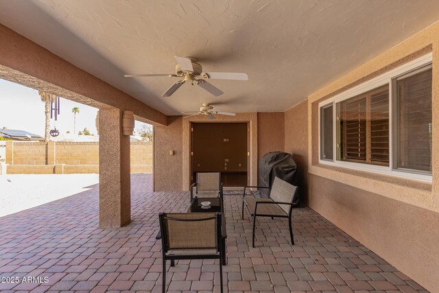 view of patio / terrace with fence and a ceiling fan