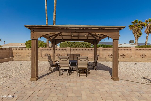 view of patio / terrace featuring outdoor dining space, a fenced backyard, and a gazebo