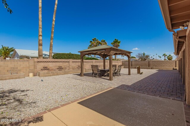 view of patio / terrace featuring outdoor dining space, a fenced backyard, and a gazebo