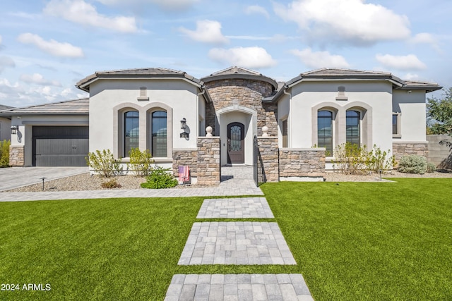 mediterranean / spanish-style house featuring a front yard and a garage